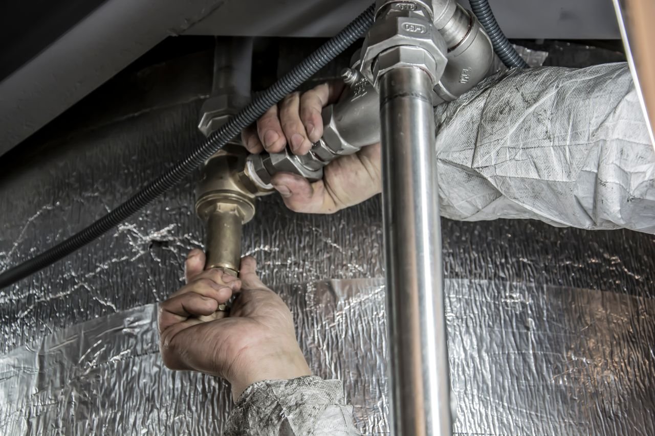 Licensed plumber repairing a pipe in a Portland home